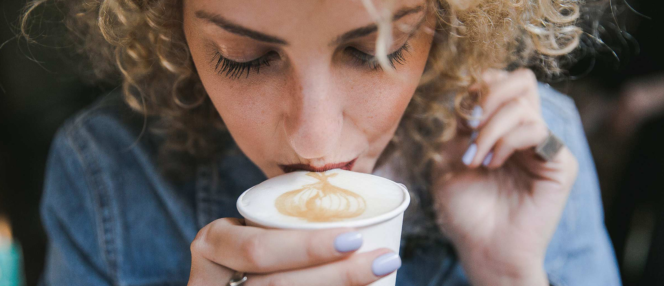 a woman drinking a delicious cup of coffee